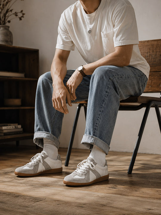 White Hector Maden low-profile sneakers worn with cuffed denim
