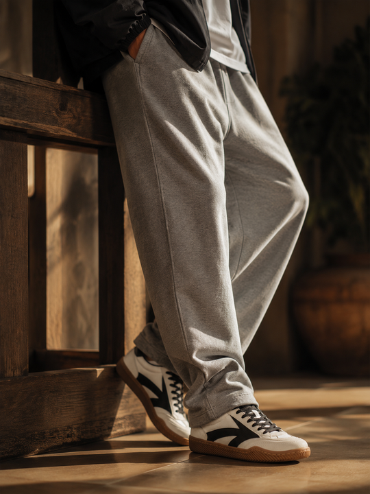 Black and white Hector Maden retro sneakers worn with grey trousers